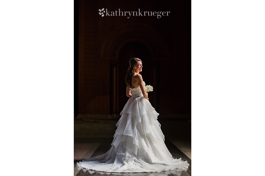 Full-length bridal portrait in front of window.