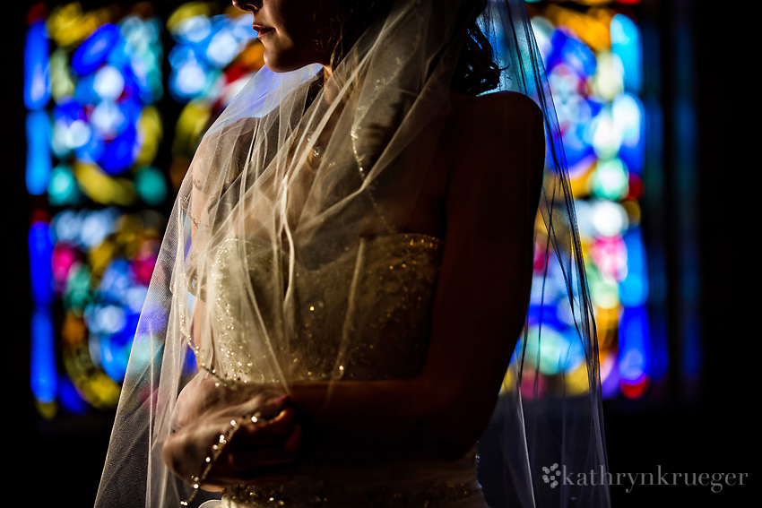 Bridal portrait in front of stained glass window. 