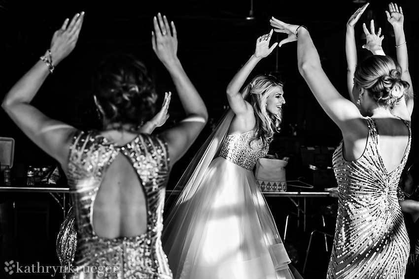 Black and white of bride dancing with bridesmaids.