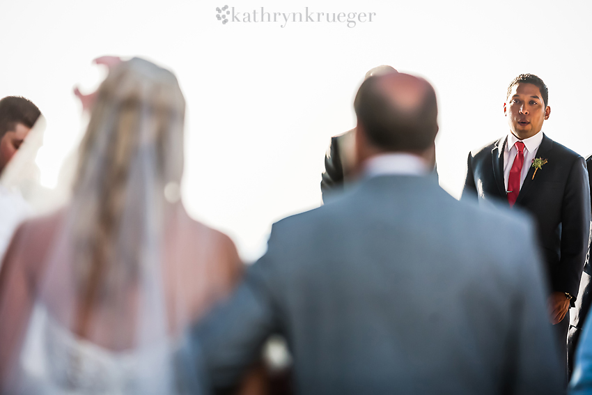 Groom seeing bride for the first time down the aisle.