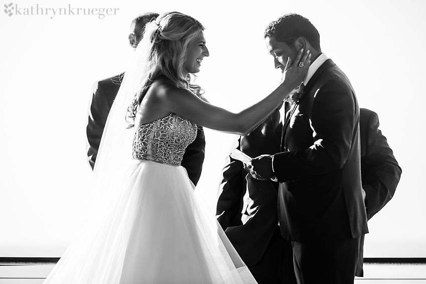 Black and white of bride wiping tear off groom's face.