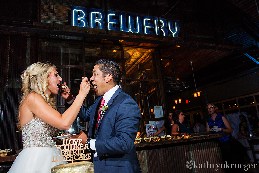 Bride and groom feed each other cake.