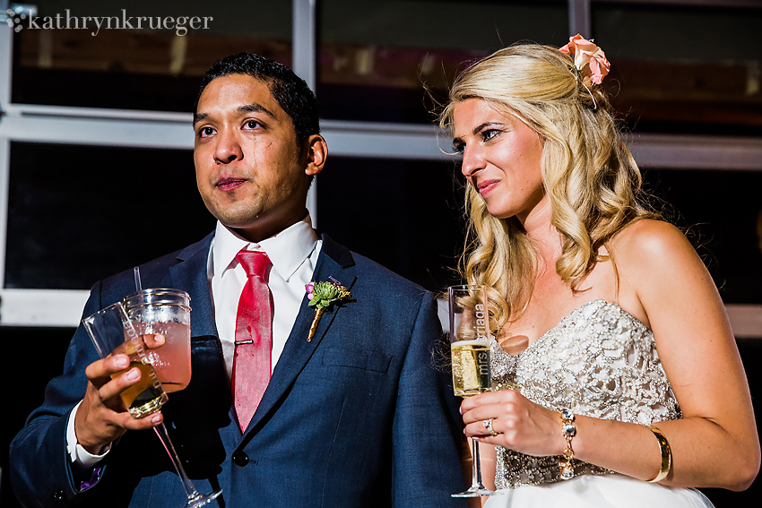 Bride and groom emotionally listening to toasts.