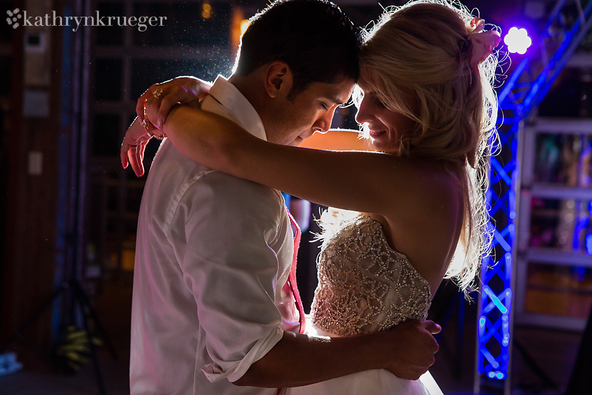 Bride and groom dancing close together.