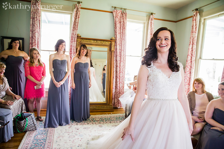 Bride standing surrounded by her bridesmaids and family.