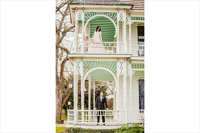 Bride and groom standing on a double deck porch.