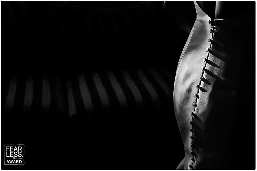 Artistic photo of bride's dress with buttons in high contrast light