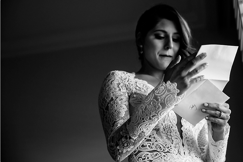 Black and white of bride reading letter from groom.