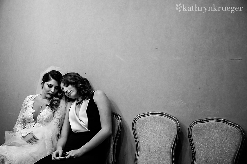 Black and white of bride and bridesmaid sitting together.