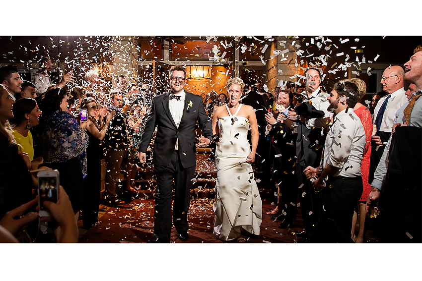 Bride and groom exit wedding with confetti. 