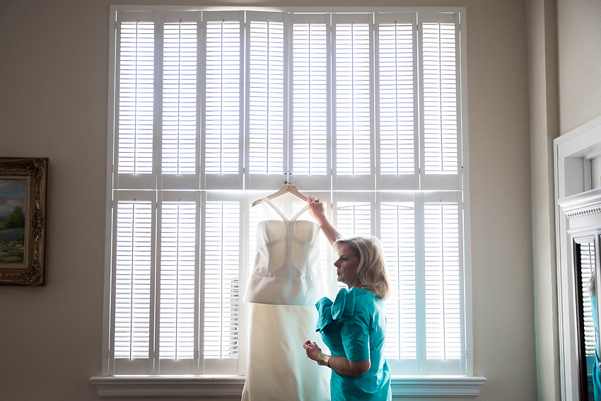 Mother of the bride bringing bride her dress.