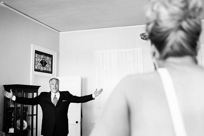 Black and white image of father seeing his daughter in wedding dress.