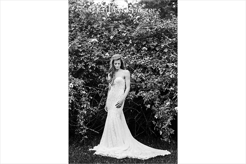 Black and white bridal portrait in front of foliage.