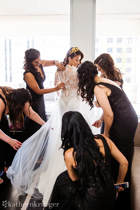 Bride being dressed by bridemaids