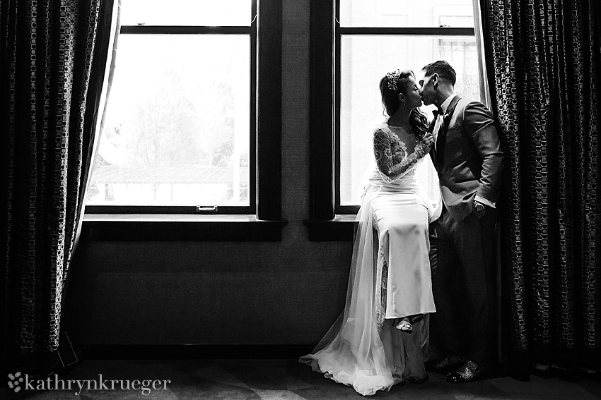 Bride and Groom kiss in a window