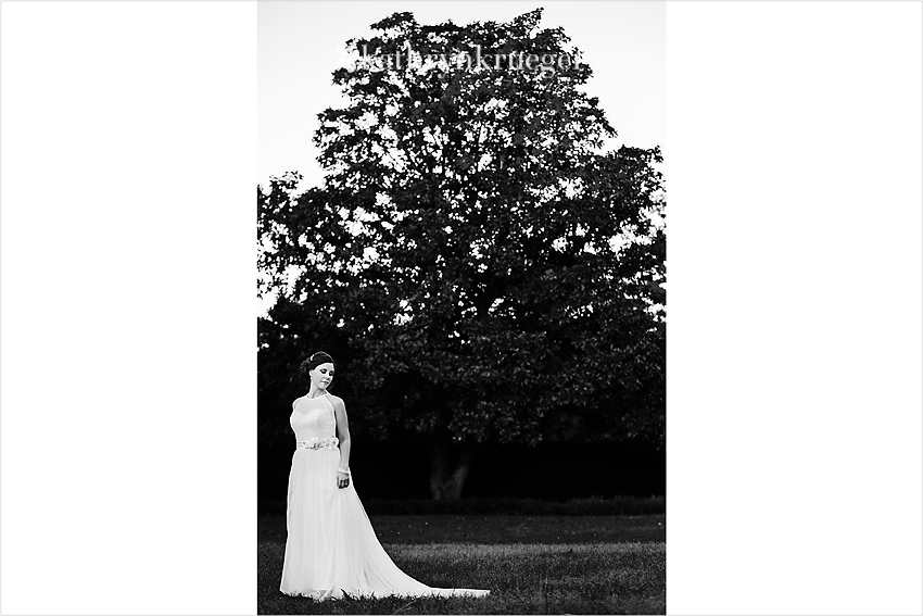 Black and white bridal portrait standing in front of large tree.