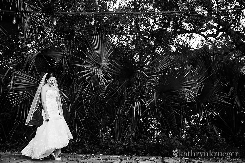 Black and white bridal portrait in front of foliage.